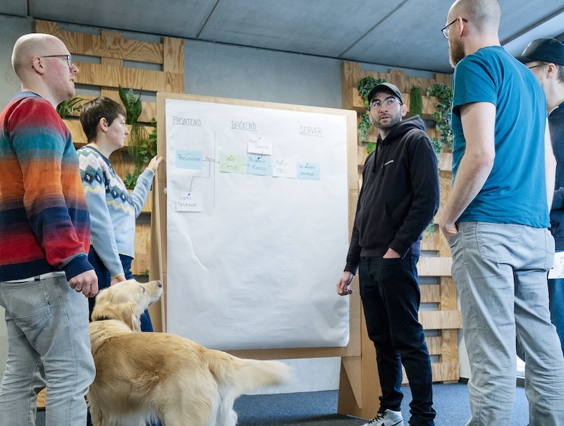 People discussing a topic in front of a board